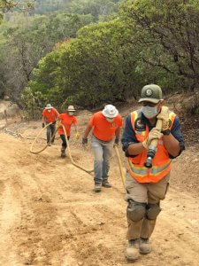 FOCC volunteers lug fire hose to work site at junction of Shoreline Trail and. Back Ranch Fire Road by Harriot Manley